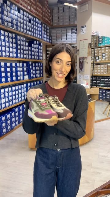 Sneaker colorata mostrata davanti alle pareti di scatole del negozio