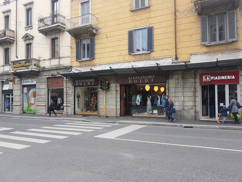 Il palazzo giallo di Via Canonica con le insegne Alessandro Doldi al piano terra